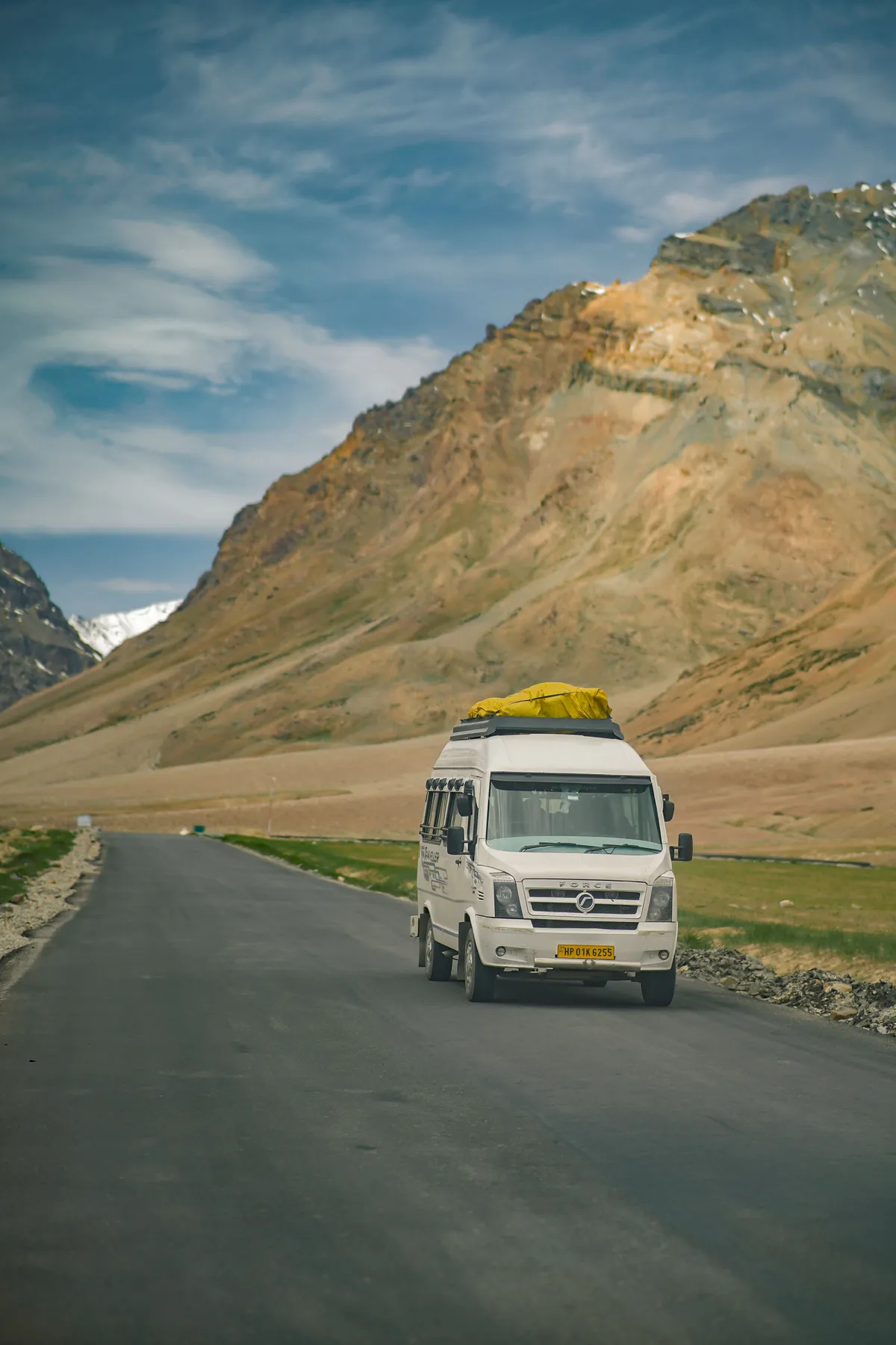 Representative white passenger van travelling on an Indian mountain road
